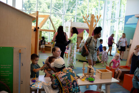 Families monitor children as they play in the children's room.