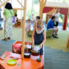 Girl with a face painting of a butterfly is seen playing with toys in the children's room.
