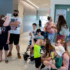 Families stand in the lobby of the library, with faces of excitement.