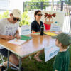 Little kid stands as author autographs a children's book.