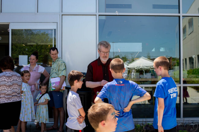 Author and children speak while looking at children's books.